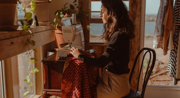 The designer sewing in the workshop