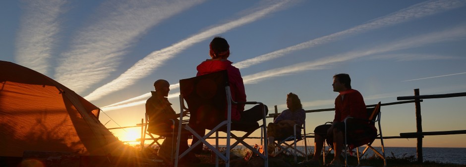 Des amis au coucher de soleil dans un camping