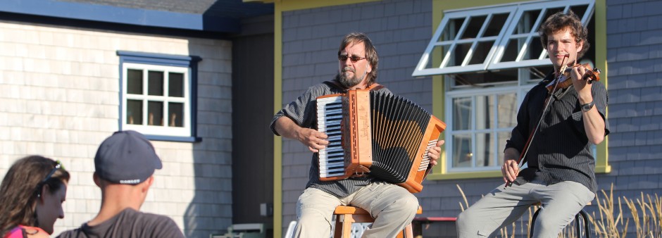 Local musicians play the accordion and violin on la Grave in front of attentive visitors