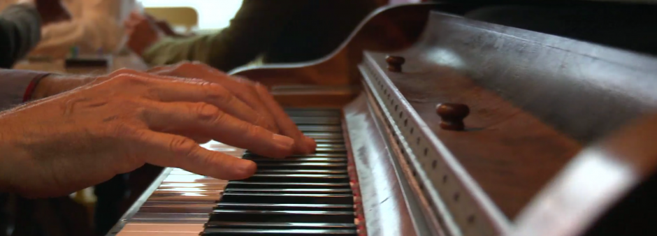 Hands on piano keys in a busy place