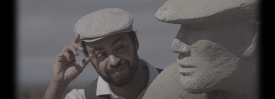 The main character of the humorous capsules salutes alongside the statue of fishermen at Étang-du-Nord