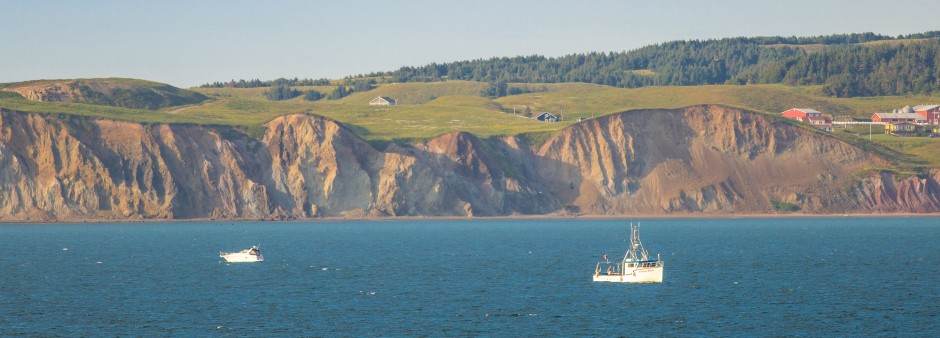 A fishing boat sailing near the shores of the Magdalen Islands