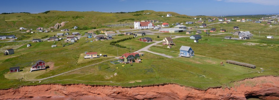  Paysage côtier de L'île du Havre aux Maisons aux Îles de la Madeleine avec maisons colorées, falaises et vue sur la mer du golfe du Saint-Laurent.