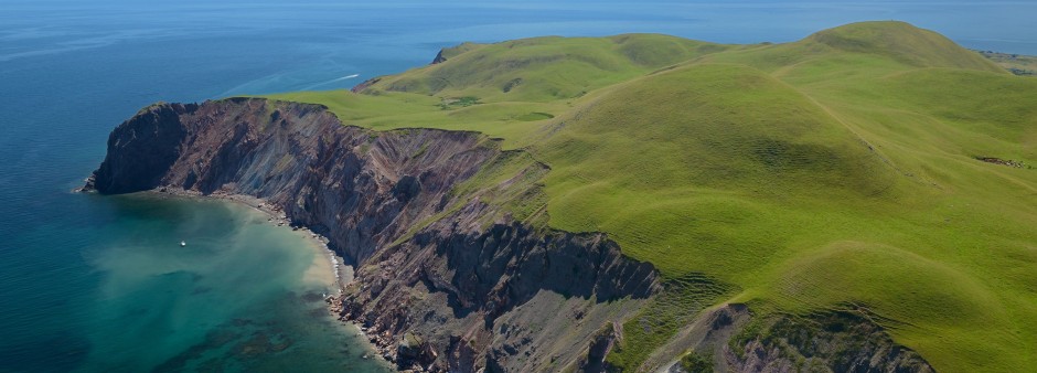 l'Île d'Entrée aux Îles de la Madeleine, avec ses collines vertes, ses falaises abruptes et ses eaux turquoise du golfe du Saint-Laurent.