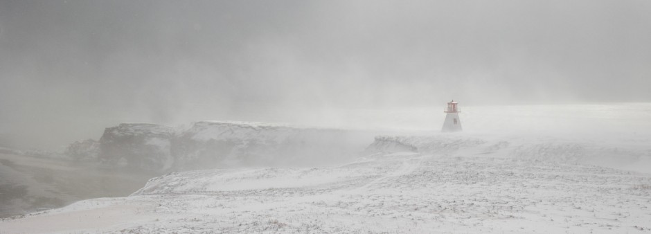 Snowstorm and gusts of wind along the edge of a red sandstone cliff, Cap Alright Lighthouse